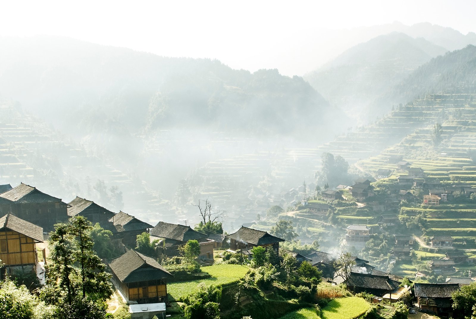 Misty mountain valley landscape and Xijiang village, Guizhou, China